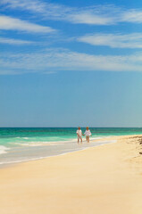 Senior couple walking on beach enjoying romantic vacation