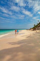 Deserted beach with retired couple walking together Bahamas