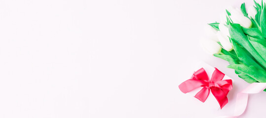 Mothers day gift. Spring white beauty flower, gift with red ribbon on flat lay white background. Valentines, birthday, women or wedding day concept.