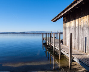 People are resting at the lake on sunny warm day in the middle of the winter