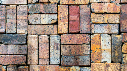 Stacked wall of colorful old reclaimed bricks 