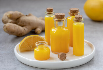 Ginger shots in a small glass bottles. Immune boosting ginger drink with ingredients ginger root...