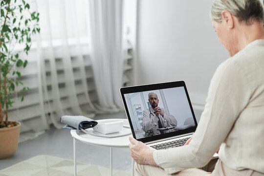 Telemedicine concept, old woman with tablet pc during an online consultation with her doctor in her living room.