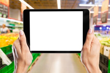 Retail management. Worker hands holding tablet on blurred supermarket background