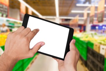 Fototapeta na wymiar Retail management. Worker hands holding tablet on blurred supermarket background
