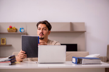 Young male employee working from house