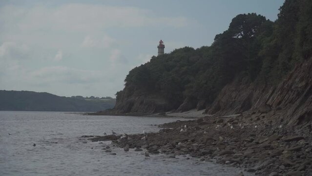 Phare Du Portzic lighthouse and the rocky shore of the ocean in the French city of Brest. View of the Phare du petit minou in Plouzane, Brittany, France. Portic Lighthouse. 
