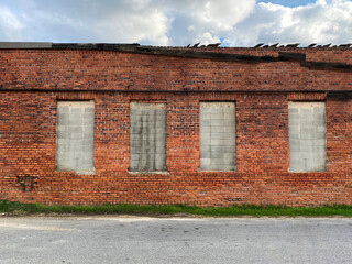 closed small town factory warehouse abandoned building red brick wall empty desolate disaster area