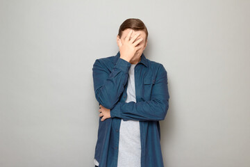 Portrait of unhappy disappointed mature man making facepalm gesture