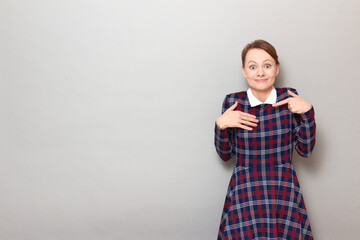 Portrait of happy young woman pointing with finger at herself