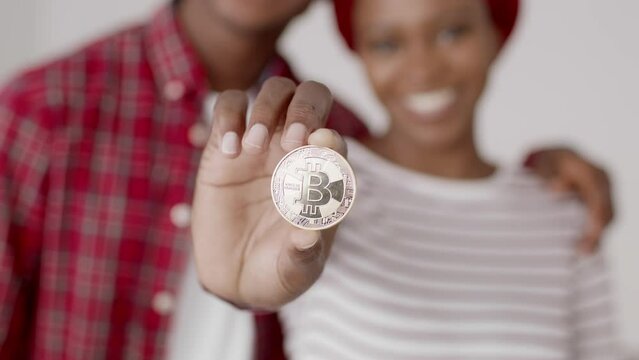 African American Couple Showing Bitcoin Standing Indoor, Closeup, Selective Focus