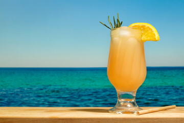Drinking glass of orange cocktail.