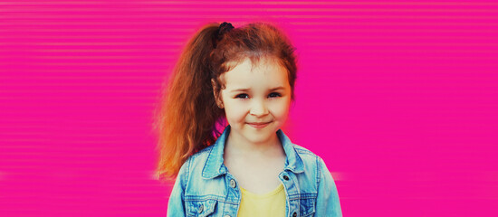 Portrait of stylish little girl child with tail haircut posing on pink background