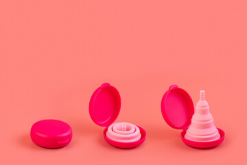 Silicone pink menstrual cups, case. Women's health and alternative hygiene on a pink background flat lay. eco-friendly, Alternative reusable product for female hygiene. Minimalism monochrome.
