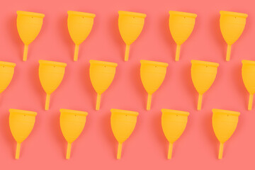 Menstrual yellow cups pattern on a pink background. Monochrome zero waste concept. eco-friendly, Alternative reusable product for female hygiene.