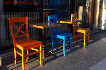 tables and yellow and blue chairs in a restaurant summer terrace