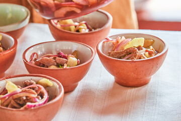 Traditionally made Mexican ceviche. Fish strips with tomato, lettuce, onion, avocado, orange.