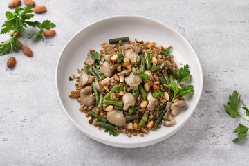 A simple steamed vegan dish. Buckwheat with green beans, oyster mushrooms, almonds and parsley. Delicious healthy homemade food