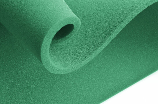 curved folds of green sponge foam sheet isolated on a white background.