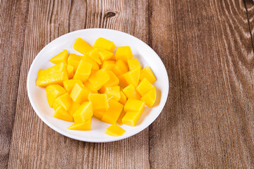 plate with pieces of mango on the table, close-up