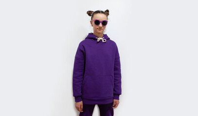 Cute teen girl in a purple hoodie. Kids hoodies mockup. Studio shot on white background.