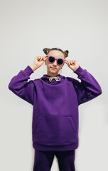 Cute teen girl in a purple hoodie. Kids hoodies mockup. Studio shot on white background.