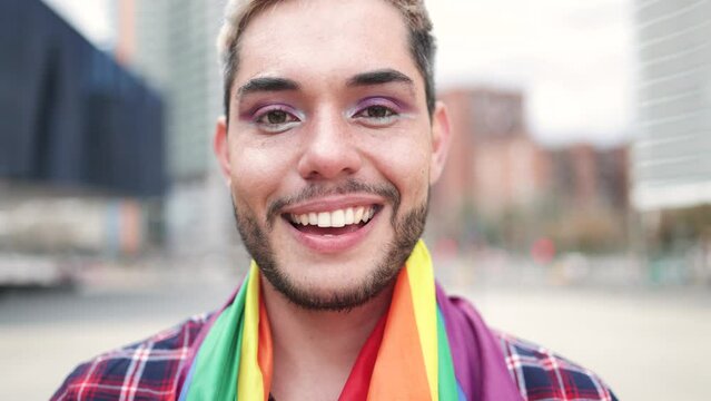 Happy gay man wearing makeup smiling on camera outdoor - Authentic LGBT non-binary people