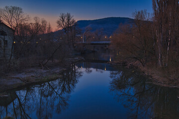 Obraz premium Abendliche Flusslandschaft der Saale zur blauen Stunde mit Spiegelung der Kernberge im ruhigen Wasser bei Sonnenuntergang, atmosphärische Natur, Jena, Kreisfreie Stadt Jena, Thüringen, Deutschland