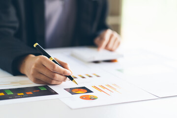Businesswoman hand pen pointing on business document at meeting discussion and analysis data the charts and graphs showing the results at meeting.Business financial and accounting concept.