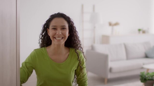 Woman Opening Door And Gesturing Inviting To Come In Indoor