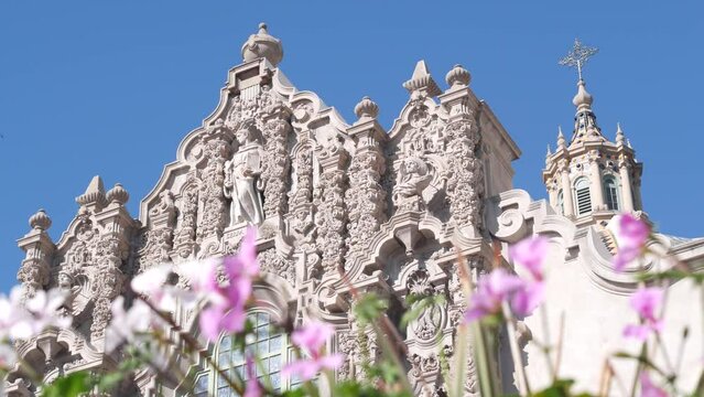 Spanish colonial revival architecture in Balboa Park, San Diego, California USA. Historic building, classic baroque or rococo romance style. Bell tower relief decor and mosaic dome or cupola. Flowers.