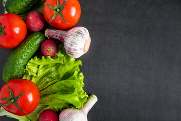 Fresh raw vegetables on a dark background. The concept of healthy eating and vegetarianism. Place for text.