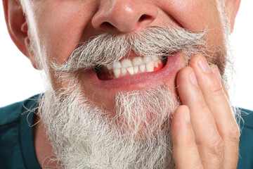 Senior man with gum inflammation on white background, closeup