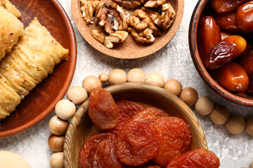 Tasty Eastern sweets with tasbih on grunge background