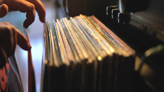 Close up man hands browsing vintage vinyl records at home. Searching music. Scene A.
