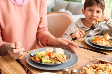 Muslim little boy with his mother having breakfast together. Celebration of Eid al-Fitr
