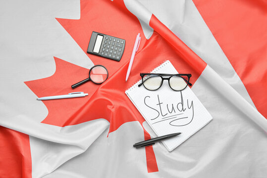 Notebook with word STUDY, eyeglasses and stationery on Canadian flag