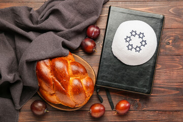 Traditional challah bread with Jewish cap and Tanakh on wooden background. Shabbat Shalom - obrazy, fototapety, plakaty