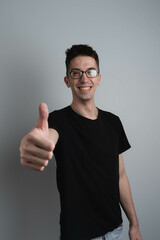 A male person in photo studio showing thumbs up in camera 