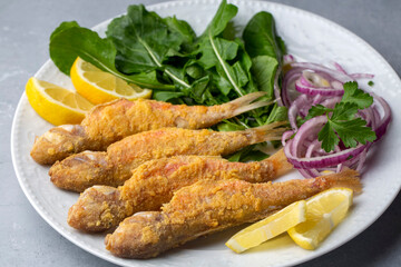 Plate of fried small fish red mullet and lemon