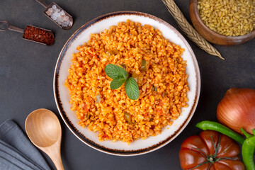 Traditional turkish bulgur pilaf with tomato sause in plate (Turkish name; meyhane pilavi)