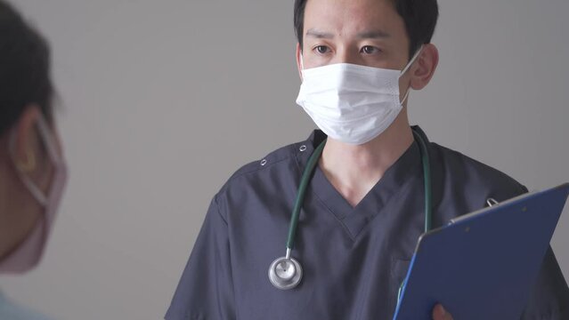 話す医療服を着た日本人男性