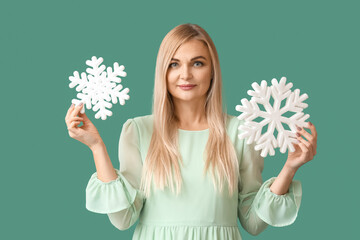 Beautiful woman with snowflakes on green background