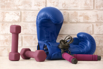Stylish sport equipment on table against brick wall