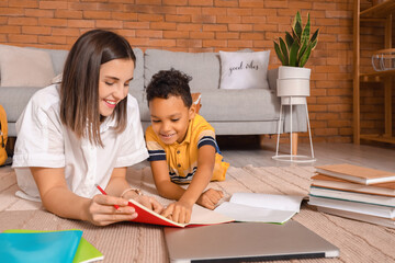Little African-American boy studying with tutor at home