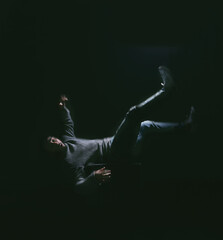 Falling your dream Thats fear of losing control. Shot of a young man falling against a dark...