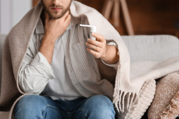 Ill man with inhaler at home