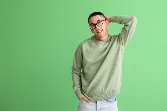 Handsome Young Asian Man In Knitted Sweater On Green Background