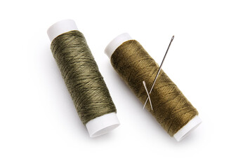 Thread spools with needle on white background