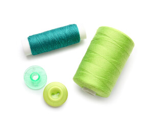 Thread spools and buttons on white background
